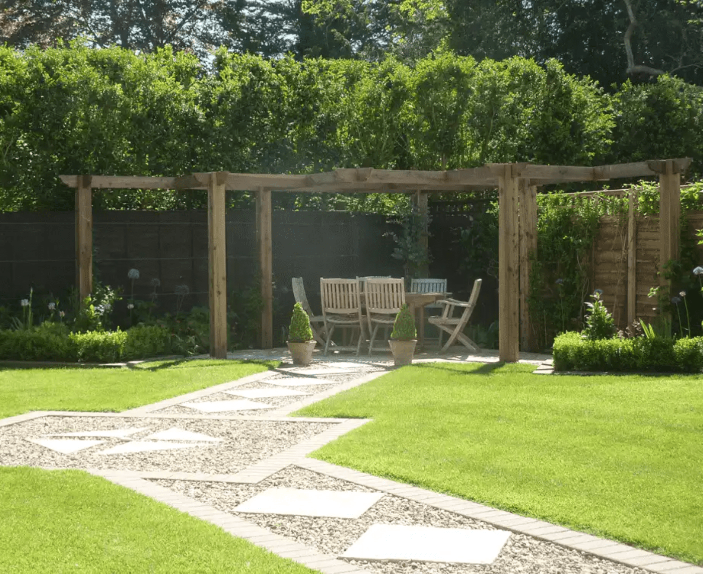 A beautifully designed pergola made from bridge timber in a garden by Cotswold Estates and Gardens.