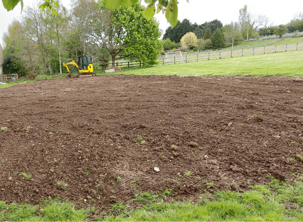 An excavator breaking through compacted soil in the TBC garden, part of project 8063.